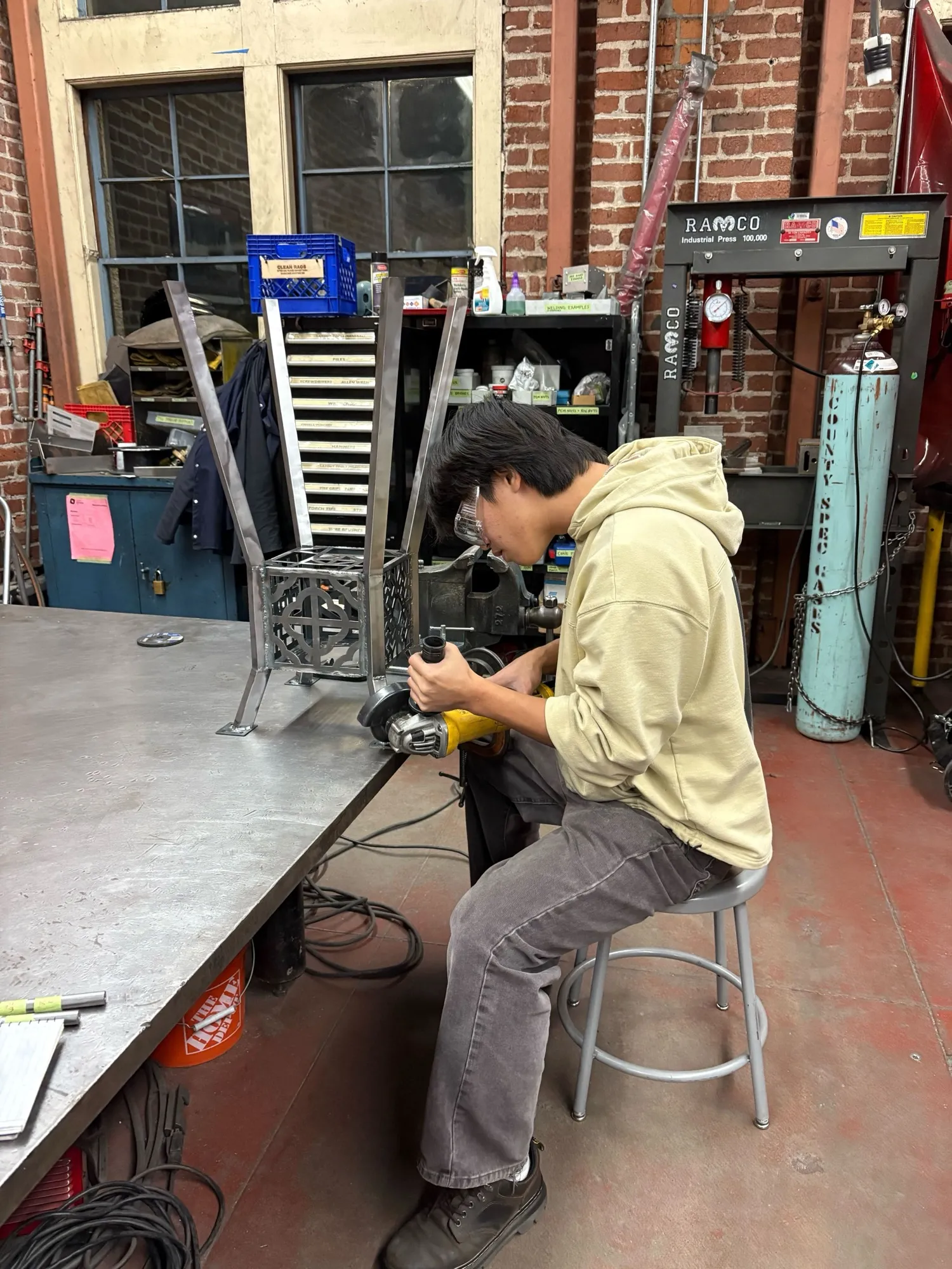 Angle grinding a weld on the steel legs
